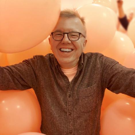 Headshot of Jim Hood surrounded by pink balloons