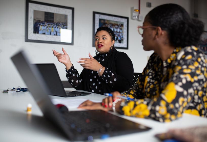 Myisha Rodrigues working with colleagues at a shared desk