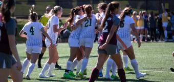 Lesley University women's soccer team celebrating a goal scored. 