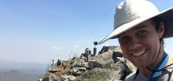 Alexander Dunn wearing a hat standing on rocky terrain