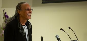 Arnetha Ball smiles as she leans into the podium in the University Hall Amphitheater.