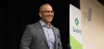 Christopher Jackson stands at the podium smiling.