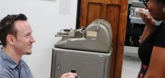 Man on one knee proposing with a jewelry box in hand