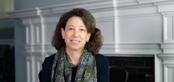 President Janet Steinmayer is wearing a scarf and dark sweater and smiling.