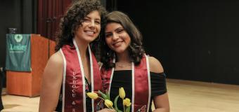 Jeannine Hernandez and Vita Franjul wearing the crimson stoles each graduate received