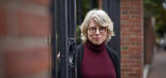 Photo of Jill Lepore standing in Harvard University gates
