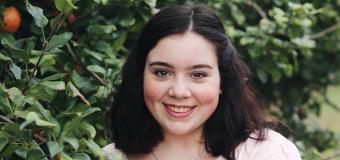 Julia Caruso standing next to an apple tree