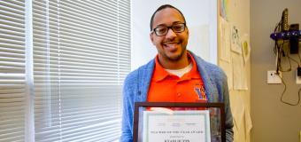 Kyair Butts holding his framed award.