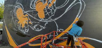 Michael Talbot works on his East Somerville mural "Artisanal."