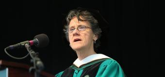 Molly Baldwin in cap and gown speaking at podium