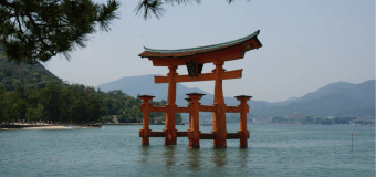 A photo of a japanese sturcture in the water.