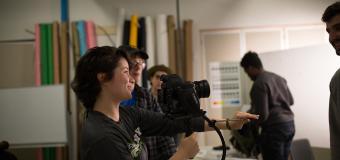 film student holds camera in classroom