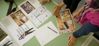 students look over print design layouts