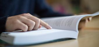 Close-up of student reading a textbook