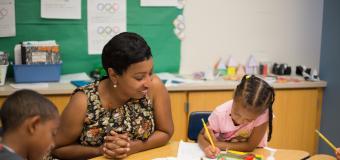 Woman in classroom at a table with two children