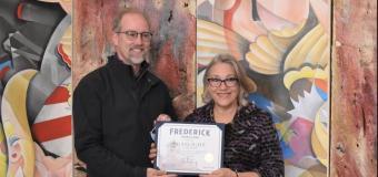 Michael O'Connor (left), the mayor of Frederick, Maryland, is pictured with Cynthia Scott during the ribbon-cutting event at Gaslight Gallery. Leigh Cortez's artwork is in the background.