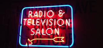 neon sign with pink letters reading RADIO & TELEVISION SALON