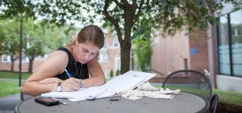 student writing in the quad 