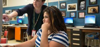 Teacher teaching a high school student at a computer