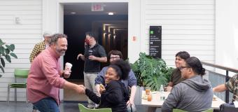 Justin Richmond greets students while wearing a pink shirt on the second floor of the Lunder Arts Center.