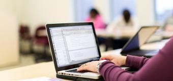 student typing on laptop
