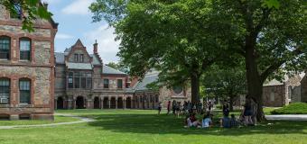Two circles of students sitting on Lesley's lawn during new student orientation.