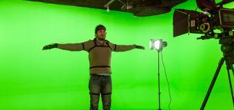 A man in Motion Capture suit in front of a green screen