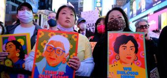 Stop Asian Hate Rally in Times Square - women holding images of asian people with words stop asian hate