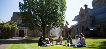 Students in an arc, chatting on Lesley's lawn.