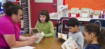 Teacher reading to a small group of students 