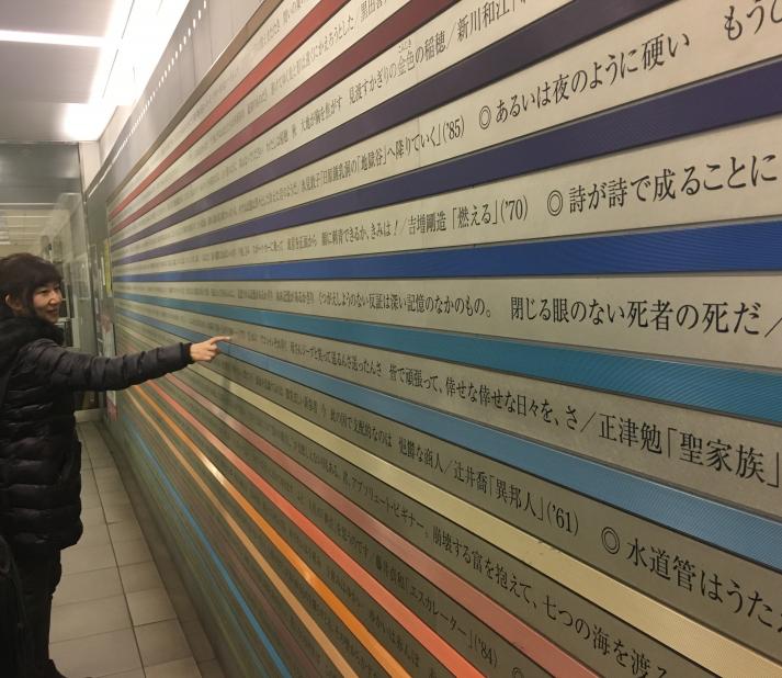 Professor Kazuyo Kubo looks at poetry printed on the walls of a subway station.