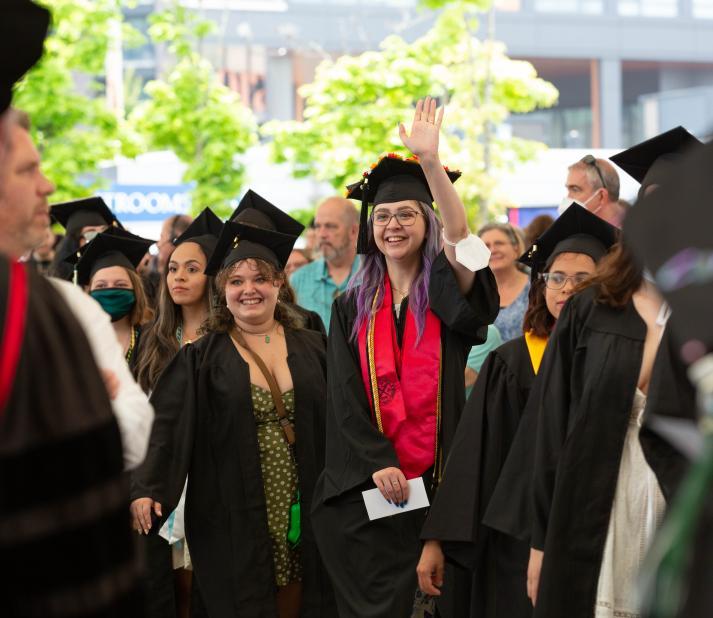 graduates greet people during commencement