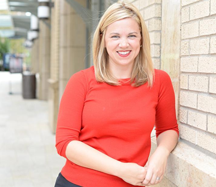 Alumna Sarah Reeves Young, standing outside by school building