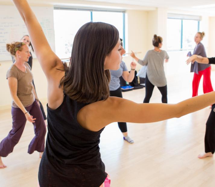 People moving and dancing in a dance studio.