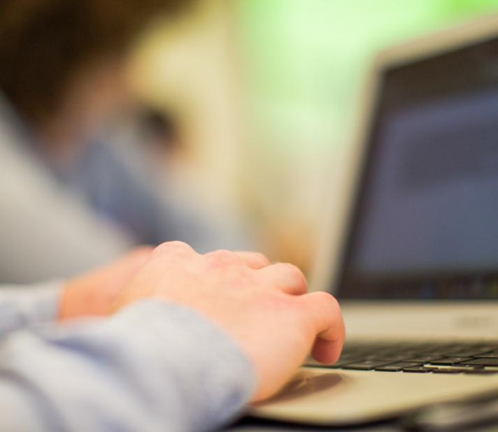 A person types on a laptop