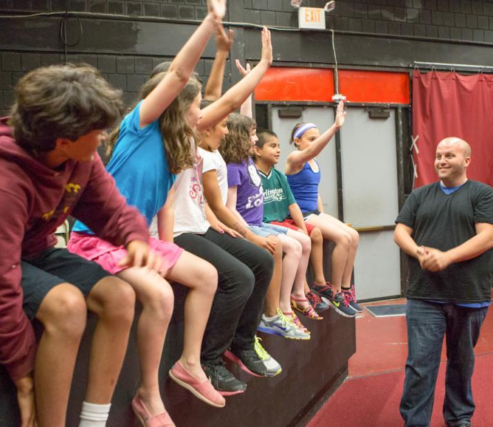 teacher with students raising hands