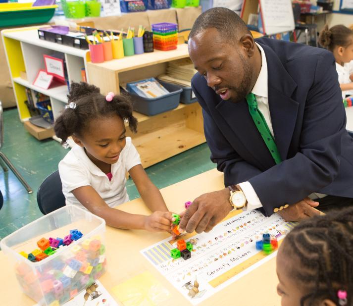 principal sitting with elementary student 