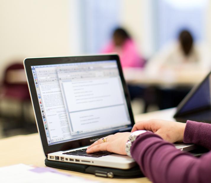 student typing on laptop