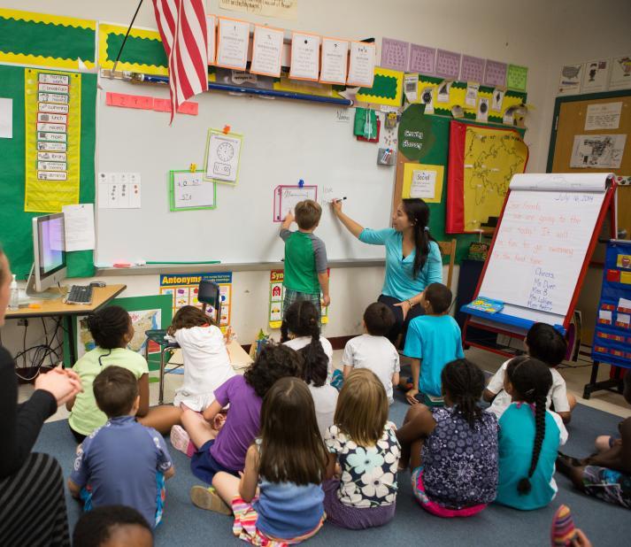 teacher teaching small children at a board