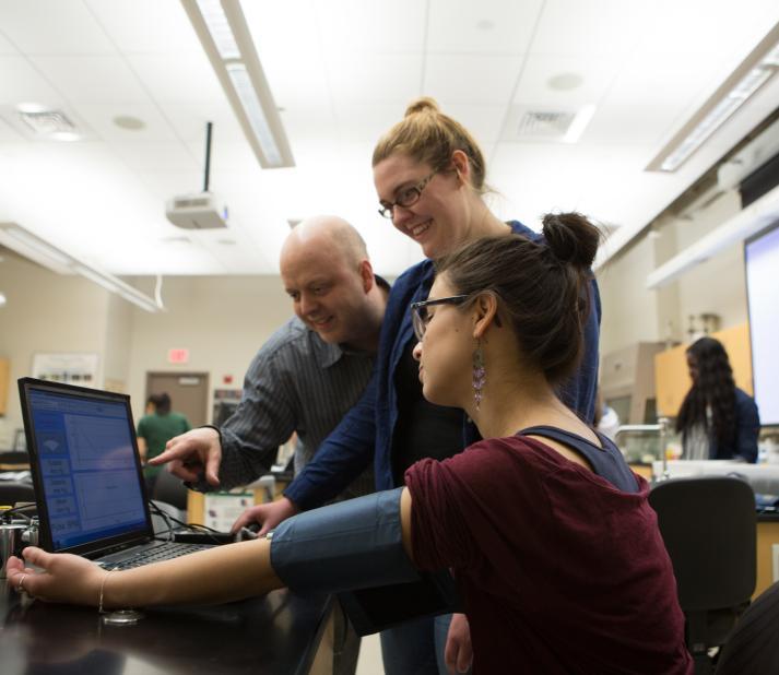 students in a science class doing a lab with professor