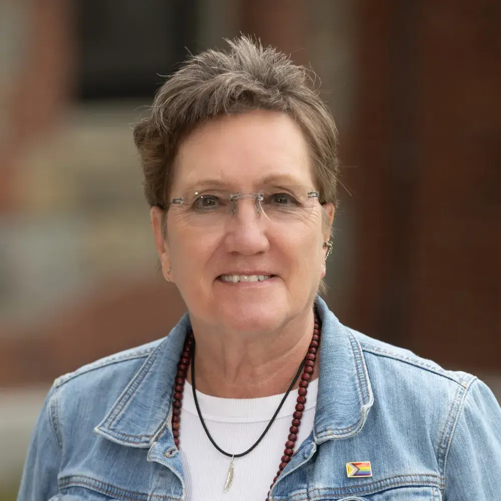 Michele smiling in a jean jacket