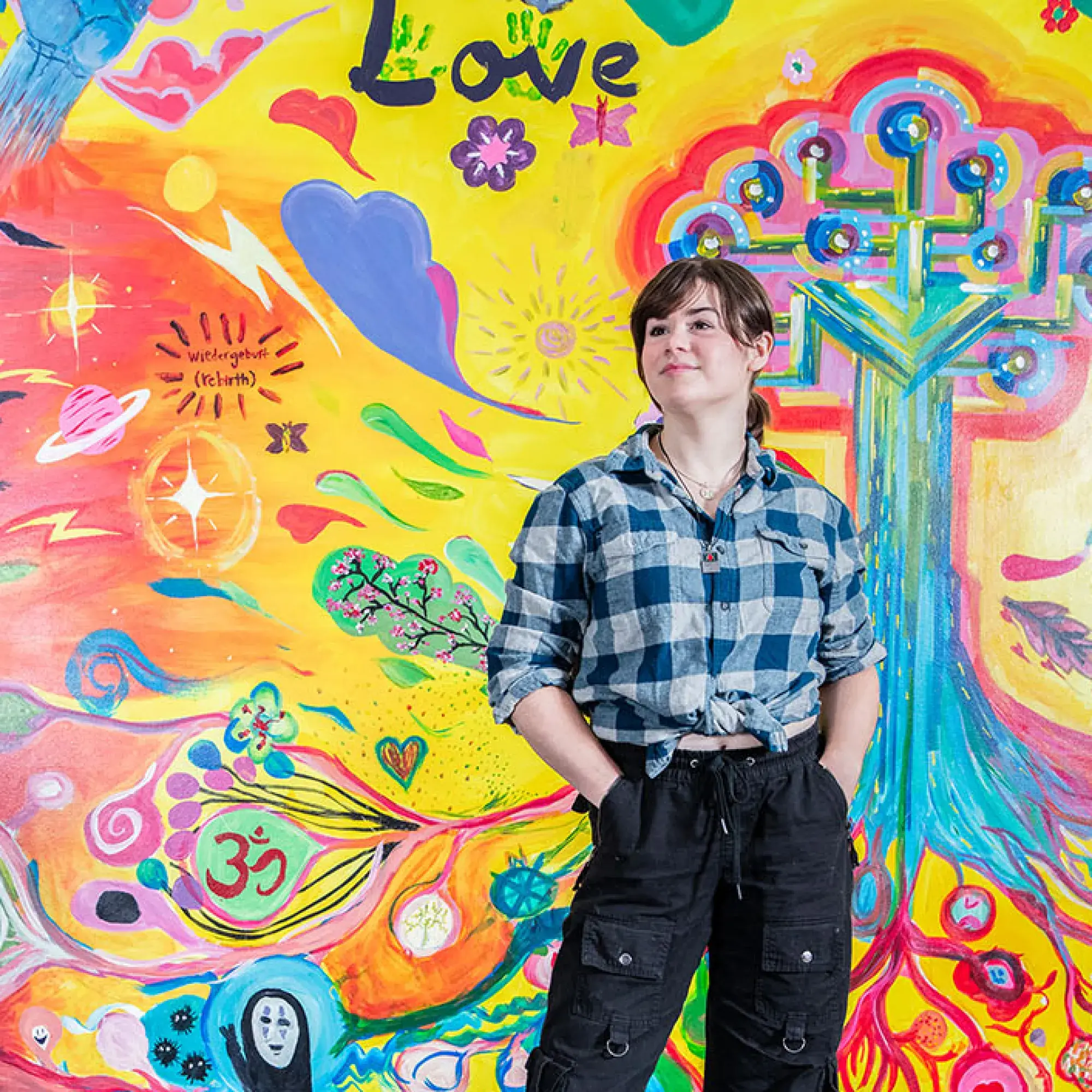 student in front of mural