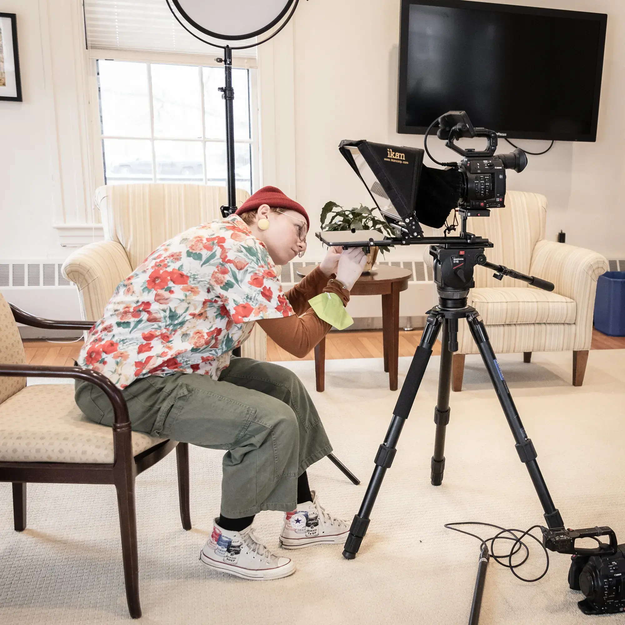 Person setting up camera equipment in common room