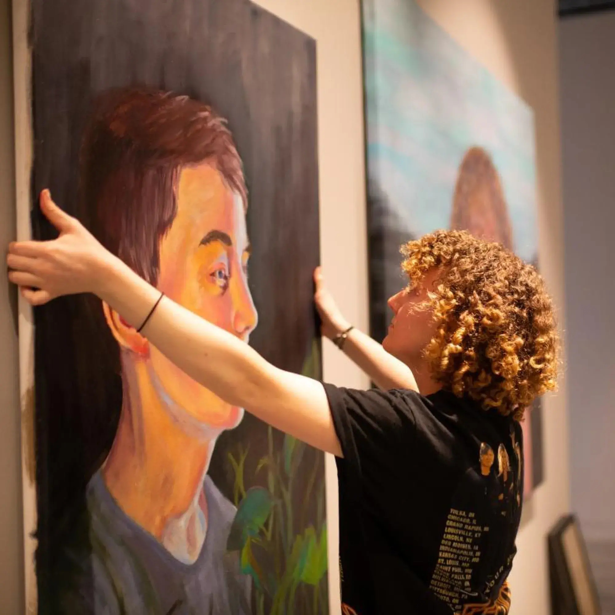 student hanging art