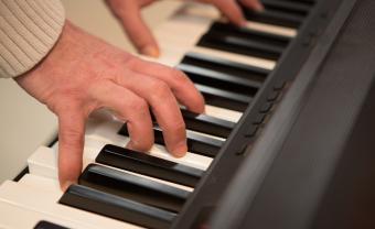 elderly hands playing a piano