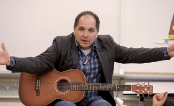 David Levine '84 gestures while holding his guitar