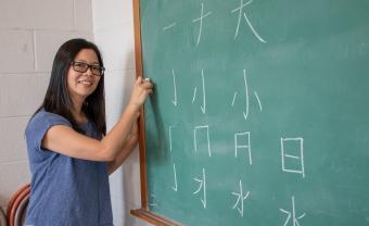 Ruiming Huang teaches Chinese characters at a blackboard