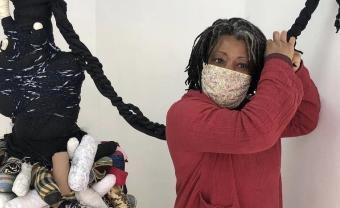 Artist Sika Foyer stands next to one of her wrapped sculptural works.