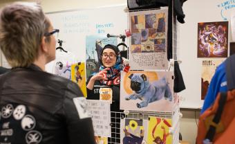 student selling artwork speaking to customer