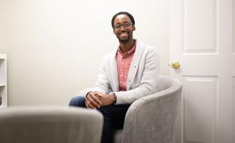 Counseling PhD Alum Brandon Jones, LMHC sitting in his office